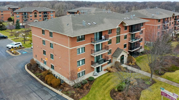 Front view of a multi-story brick apartment building with balconies.