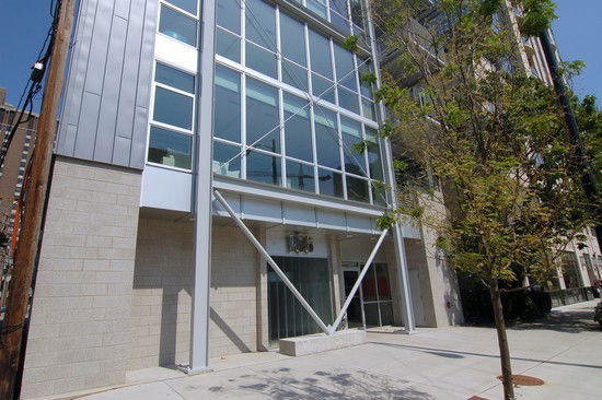 Front view of a modern multi-story building with large glass windows.