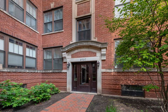 Front view of a brick building entrance with arched doorway.