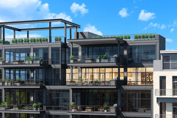 Front view of a modern multi-story building with large glass windows and balconies.