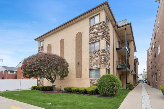 Front view of a multi-story apartment building with brick and stone facade.