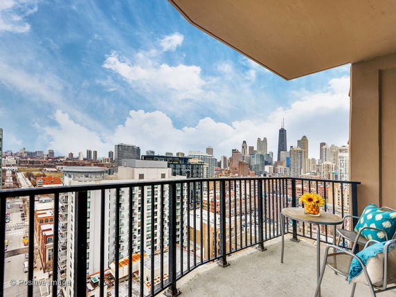 Balcony view from a high-rise building overlooking a cityscape with skyscrapers.