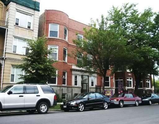 Front view of a multi-story brick building with adjacent buildings.
