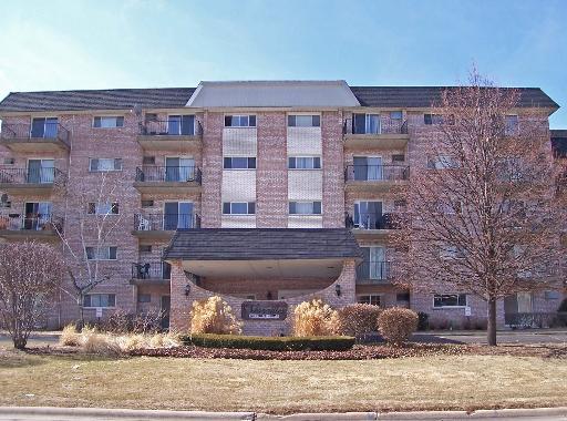 Front view of a multi-story brick building with balconies.