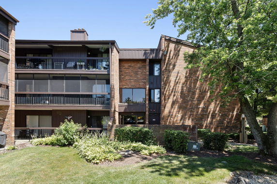 Front view of a multi-story brick apartment building with balconies.