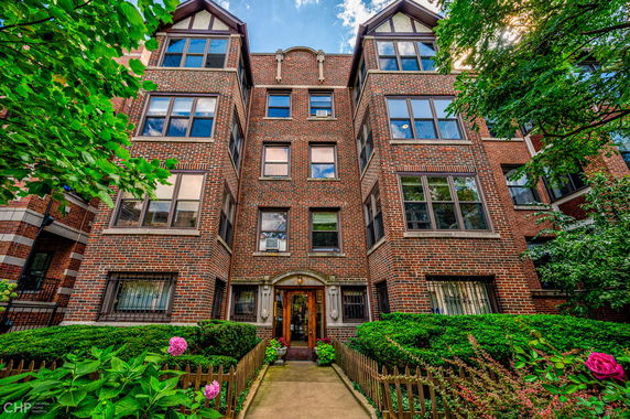Front view of a multi-story brick building with large windows.