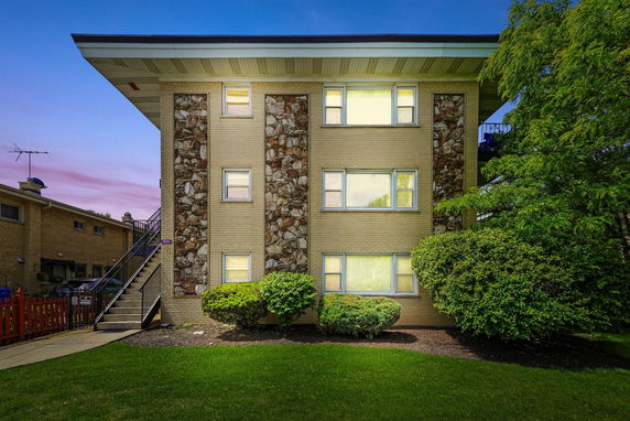 Front view of a three-story apartment building with brick and stone facade elements.
