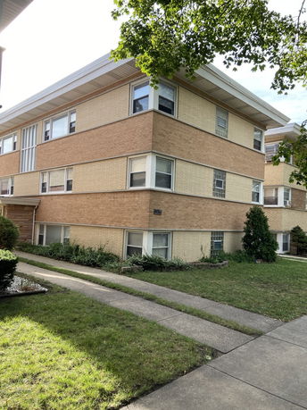 Front view of a three-story brick apartment building.