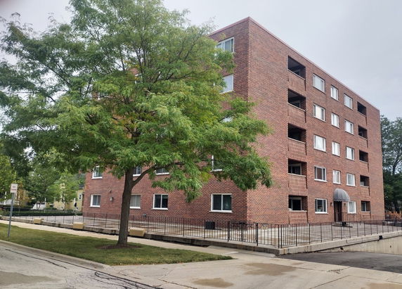 Front view of a brick multi-story apartment building.