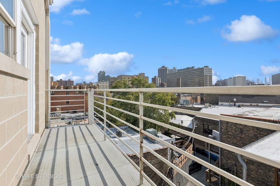 View of surrounding buildings from a balcony with railing.