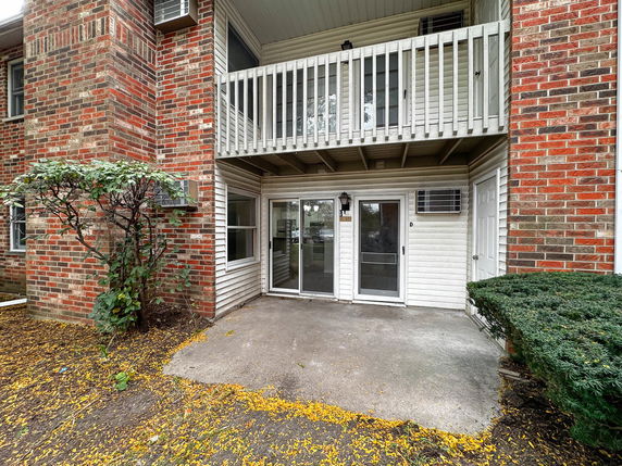 Exterior view of a brick and siding apartment building with balconies.