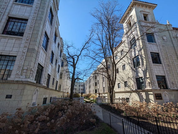 Exterior view of multi-story buildings with architectural details and large windows.