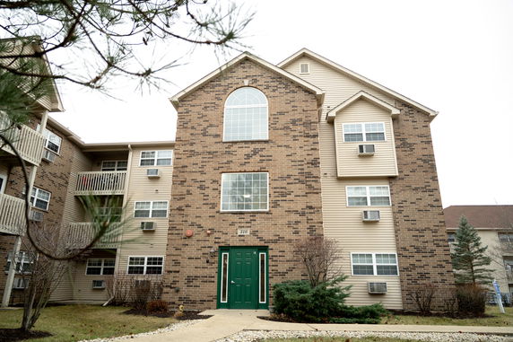 Front view of a multi-story building with brick and siding exterior.