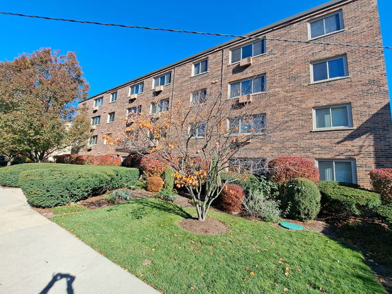 Front view of a multi-story brick apartment building.