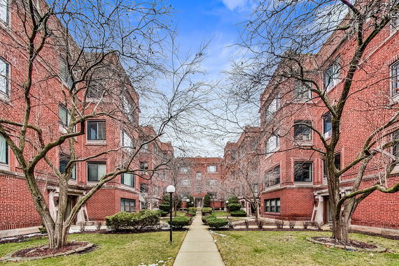 Front view of a red brick apartment complex with multiple entrances.