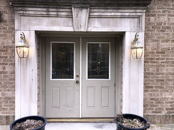Front view of a building entrance with double doors and decorative lanterns.