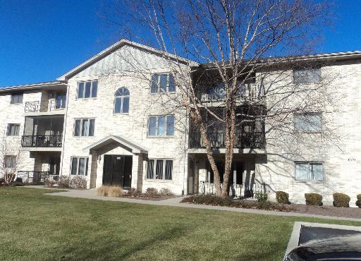 Front view of a multi-story residential building with balconies and entrance.
