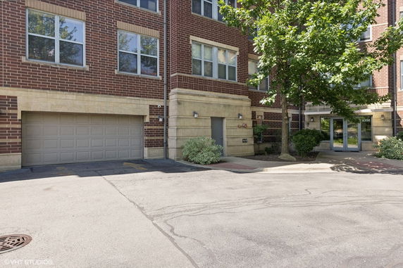 Front view of a multi-story building with brick exterior and a garage entrance.
