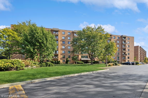 Front view of a multi-story apartment building with balconies.
