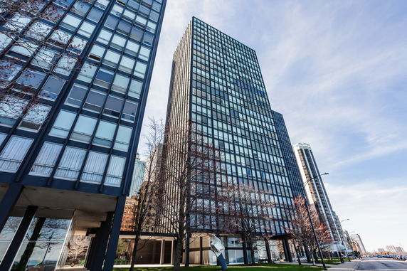 Front view of a tall modern high-rise building with a glass facade.