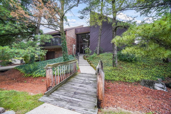 Front view of a building with a wooden bridge leading to the entrance.