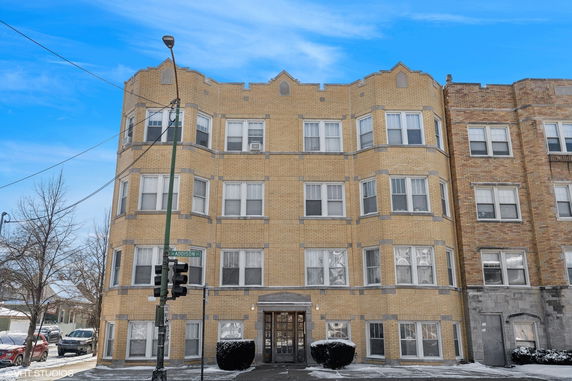 Front view of a multi-story brick building with symmetrical windows.