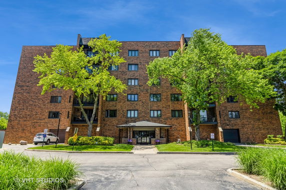 Front view of a multi-story brick building with large windows and a central entrance.