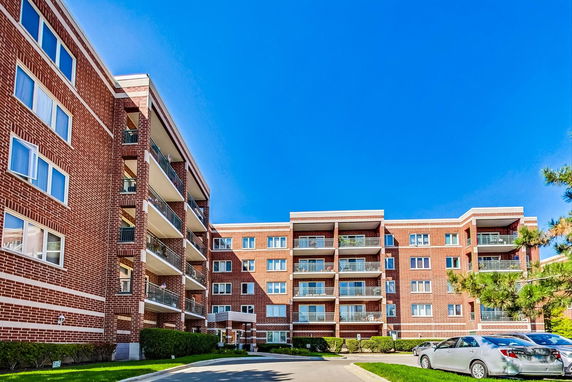 Front view of a multi-story apartment building with balconies.