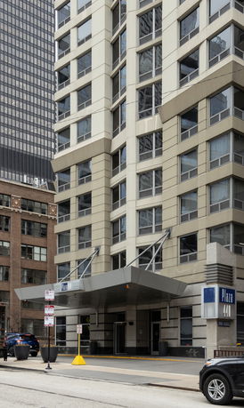 Front view of a multi-story building with a modern design and canopy entrance.