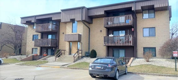 Front view of a multi-story apartment building with balconies.