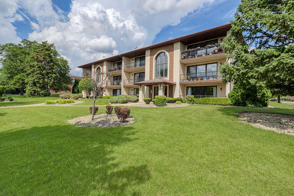 Front view of a multi-story apartment building with balconies.
