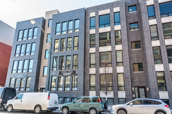 Front view of a multi-story brick apartment building.