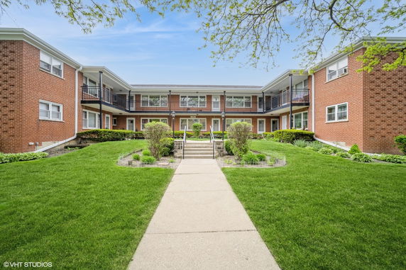 Front view of a multi-story brick building with a central courtyard.