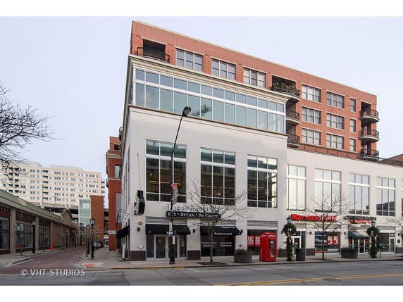 Front view of a multi-story commercial building with large windows and brick facade.