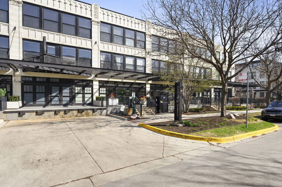 Front view of a multi-story commercial building with large windows and a canopy.
