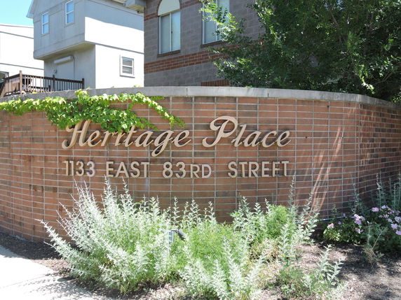 Front view of a building with a sign reading 'Heritage Place 1133 East 83rd Street.'