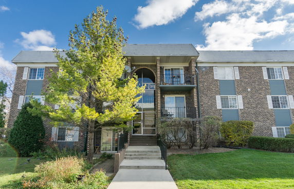 Front view of a multi-story apartment building with a central entrance.