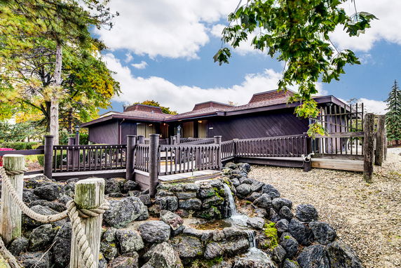 Front view of a single-story house with a wooden deck and railing.