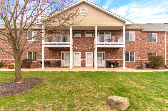 Front view of a two-story brick apartment building with balconies.