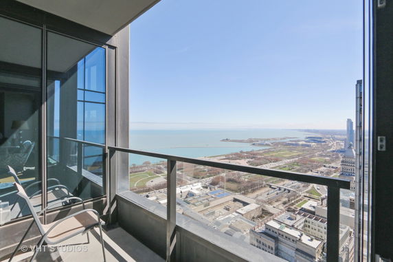 Panoramic view of city and coastline seen from a high balcony.
