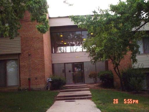 Front view of a multi-story building with brick facade and large windows.