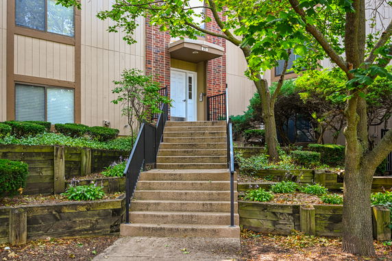 Front view of a house with a staircase leading to the entrance.