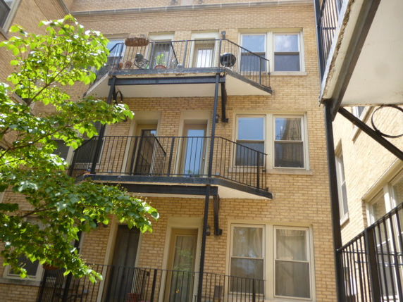 View of a multi-story building with balconies and metal railings.