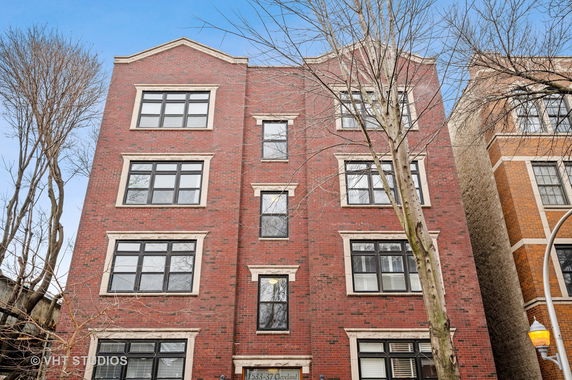 Front view of a multi-story brick building with multiple windows.