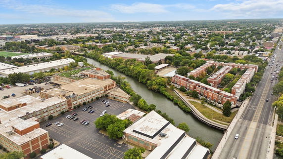 Panoramic view of an urban area with a river, buildings, and roads.