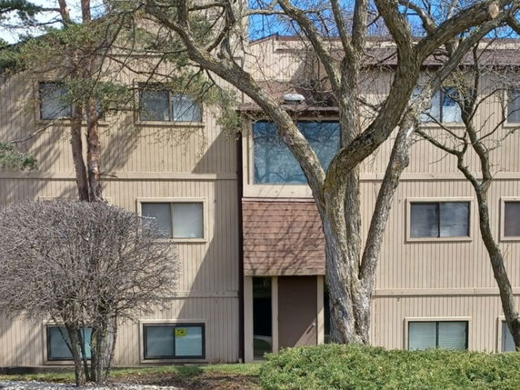 Front view of a multi-story building with rectangular windows and a flat roof.