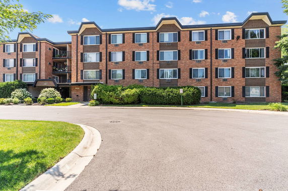 Front view of a four-story brick apartment building.