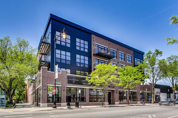 Front view of a multi-story commercial building with glass and brick facade.