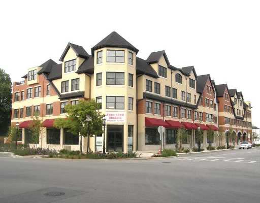 Front view of a multi-story building with unique architectural features and red awnings.