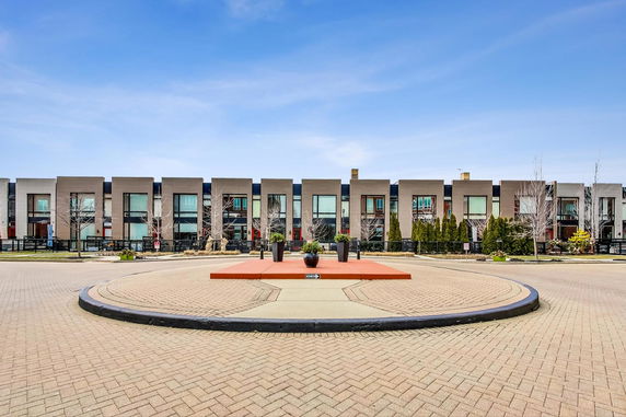 Front view of a row of modern townhouses with large windows and minimalistic design.